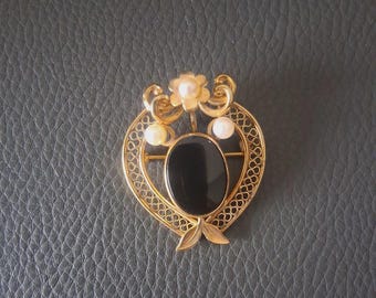 Broche ovalado vintage de ónix negro ornamentado con una flor de perla
