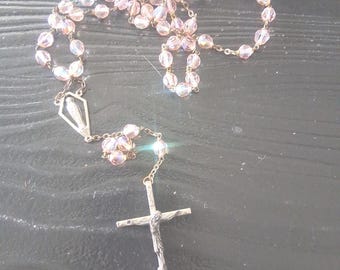Rosario con crucifijo de plata de ley y cuentas de cristal rosa facetadas de estilo antiguo.