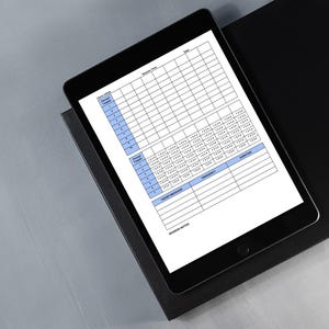 May include: A black tablet displaying a detailed workout log template with blue and white sections. The tablet rests on a black surface, angled against a gray background. The template includes sections for sets, reps, and notes.