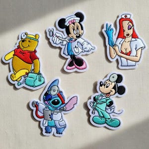 May include: Embroidered patches featuring cartoon characters dressed as medical professionals. Includes Winnie the Pooh, Minnie Mouse, Jessica Rabbit, Stitch, and Mickey Mouse, each with medical tools and attire. Patches are colorful with white borders.