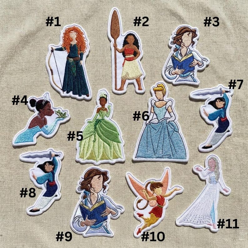 Op de afbeelding: Geborduurde patches met verschillende stripfiguren. De patches bevatten een personage met rood haar dat een pijl en boog vasthoudt, een personage dat een speer vasthoudt, een personage dat een boek leest, een personage met een kikker, en meer.