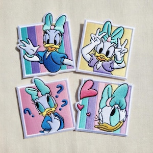 Könnte beinhalten: Vier gestickte Aufnäher mit Daisy Duck in verschiedenen Posen. Jeder Aufnäher hat einen weißen Rand und einen farbenfrohen gestreiften Hintergrund. Daisy wird mit ihrer charakteristischen Schleife dargestellt, in verschiedenen Outfits und Gesten.