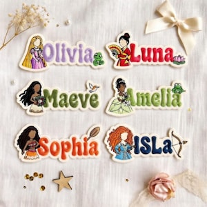 May include: Embroidered name patches with princess illustrations. Names include Olivia, Luna, Maeve, Amelia, Sophia, and Isla. Each patch has a princess character and a name in a matching colour. Patches are on a white background.