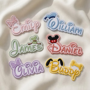 May include: Six embroidered name patches featuring Disney-inspired motifs. The names Emily, William, James, Daniel, Olivia, and Buddy are stitched in various colors including pink, blue, green, red, purple, and yellow with character icons.