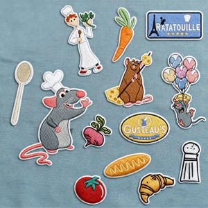 Può includere: Toppe ricamate con personaggi e cibo del film Ratatouille. Include uno chef, un ratto, una carota, una baguette, un croissant e la Torre Eiffel con la scritta "Ratatouille". Le toppe sono di vari colori e dimensioni.