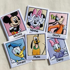 以下が含まれることがあります： ディズニーキャラクター、ミッキー、ミニー、グーフィー、ドナルド、プルート、デイジーの刺繍ワッペン。各ワッペンは白い縁取りがあり、キャラクター名が下にあります。キャラクターは鮮やかな色です。