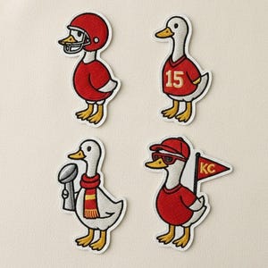 May include: Four embroidered patches featuring ducks in red and white outfits. One duck wears a football helmet, another a jersey with the number 15, a third holds a trophy, and the last wears sunglasses and a KC flag.