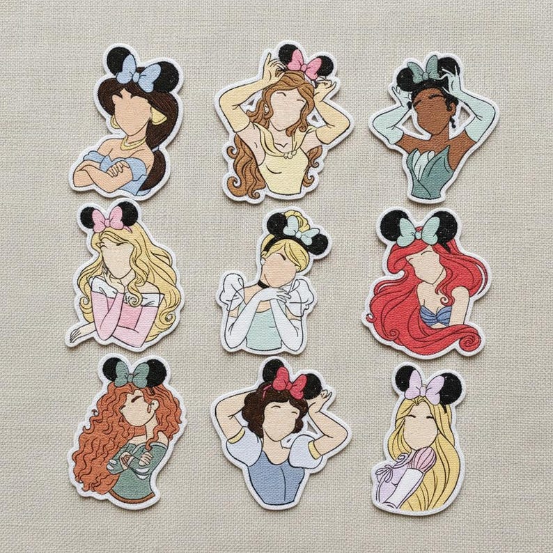 May include: Nine colorful cartoon stickers featuring Disney princesses wearing Minnie Mouse ears. Each sticker has a unique hairstyle and outfit, with a variety of colors including blue, yellow, pink, and red. The stickers are outlined in white.