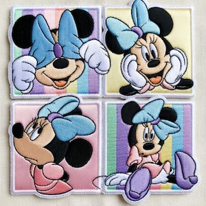 May include: Four embroidered patches featuring Minnie Mouse in various poses. Each patch has a different pastel background with vertical stripes. Minnie Mouse is wearing a blue bow and a pink dress in some of the patches.