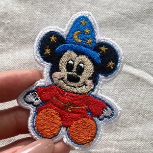 May include: A set of three ceramic canisters with lids. The canisters are white with a blue floral pattern. The largest canister is 8 inches tall, the medium is 7 inches, and the smallest is 6 inches.