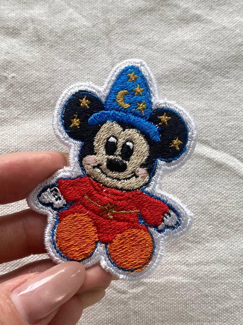 May include: A set of three ceramic canisters with lids. The canisters are white with a blue floral pattern. The largest canister is 8 inches tall, the medium is 7 inches, and the smallest is 6 inches.