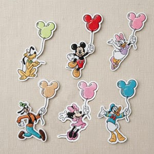 Op de afbeelding: Geborduurde patches met Disney-personages, waaronder Mickey Mouse, Minnie Mouse, Donald Duck, Daisy Duck, Goofy en Pluto. Elk personage houdt een Mickey Mouse-vormige ballon vast in verschillende kleuren, zoals rood, roze en blauw.