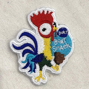 Pu&ograve; includere: Toppa ricamata raffigurante un gallo dei cartoni animati con cresta rossa, corpo giallo e penne della coda blu. Il gallo tiene in mano una borsa blu con la scritta "Boat Snack". La toppa ha un bordo bianco.
