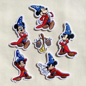 May include: A white ceramic mug with a black handle and the text "But first, coffee" in a handwritten style. The mug is on a white surface. The mug is approximately 4 inches tall.