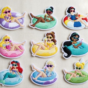 Puede incluir: Parches bordados con personajes de dibujos animados relajándose en flotadores inflables. Cada personaje lleva gafas de sol y sostiene un dulce. Los parches tienen un borde blanco y están sobre un fondo neutro.