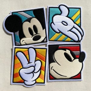 May include: Four embroidered patches featuring Mickey Mouse. One patch shows Mickey's face, two show his gloved hand, and one shows a peace sign. Each patch is square with a white border and colorful background.