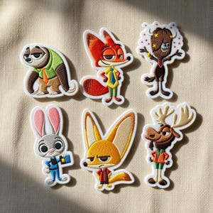 Puede incluir: Conjunto de seis parches bordados con personajes de una película de animación popular. Los parches incluyen un perezoso, un zorro, un conejo, un fennec, un alce y un búfalo de agua. Cada parche tiene un borde blanco.