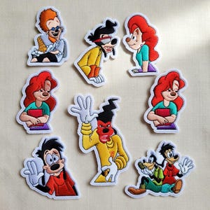 May include: A collection of eight embroidered patches featuring various cartoon characters from the Goofy Movie franchise, including Max, Goofy, and Roxanne, depicted in colorful outfits with distinct expressions and poses on a white background.