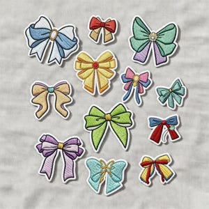 Op de afbeelding: Een verzameling geborduurde strikpatches in verschillende kleuren, waaronder blauw, groen, geel en paars. Elke patch heeft een gedetailleerd ontwerp met een witte rand, perfect voor het decoreren van kleding of accessoires.