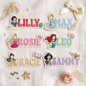 Puede incluir: Parches bordados con nombres y princesas Disney. Los nombres Lilly, Max, Rosie, Leo, Gracie y Sammy se muestran con ilustraciones de princesas. Los parches son de varios colores, incluyendo rosa, azul y verde.