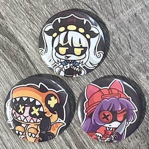 May include: Three round black buttons with colorful anime-style character designs. One features a white-haired character with a black and white outfit. Another shows an orange dinosaur-like character. The third button has a purple-haired character with a red outfit.