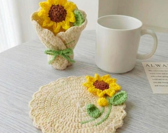 May include: A crocheted sunflower coaster with a matching bouquet and a white mug. The coaster is cream-colored with a yellow, brown, and green sunflower design. The bouquet features a yellow sunflower and green leaves.