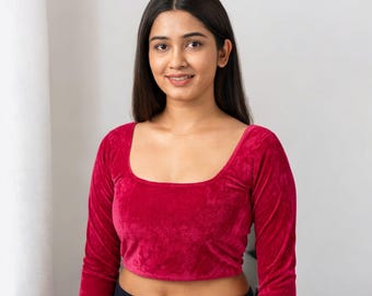 May include: A cropped, long-sleeve top in a vibrant red hue. The top features a square neckline and is made of a soft, velvety material. The garment is paired with black bottoms.