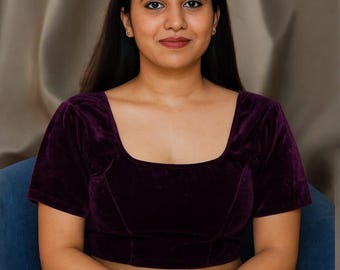 May include: A plum-colored velvet top with a square neckline and short sleeves. The top is a solid color and appears to be made of a soft, luxurious fabric. The garment is a blouse or a crop top.