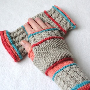 May include: Hand-knitted fingerless gloves in a neutral gray with a textured pattern. The cuffs and edges are accented with coral, turquoise, and red stripes. These warm, cozy gloves are perfect for cool weather.