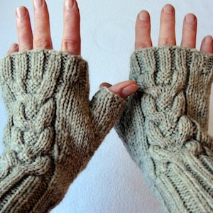 May include: A pair of beige fingerless gloves with a cable knit pattern. The gloves are made of a soft, warm yarn and are perfect for keeping your hands warm in the winter.