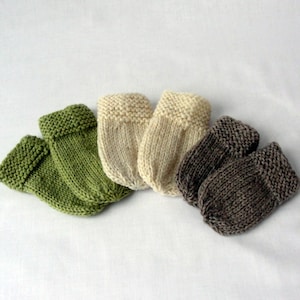 Puede incluir: Cuatro pares de botines de bebé tejidos en verde, beige y marrón.