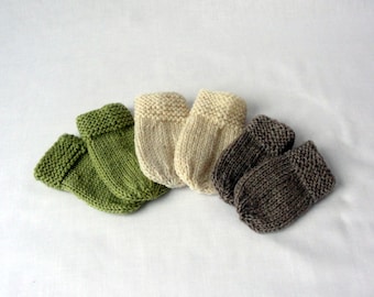 May include: Four pairs of knitted baby booties in green, beige and brown.