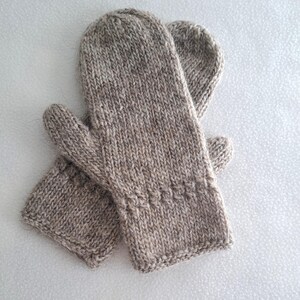 Könnte beinhalten: Ein Paar braune Strickhandschuhe mit einem strukturierten Muster. Die Handschuhe sind aus einem weichen, warmen Material gefertigt und perfekt, um Ihre Hände im Winter warm zu halten.