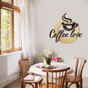 May include: A cozy interior scene featuring a round table set for two, with wooden chairs and a vase of flowers. A wall decoration with the words "Coffee love" and a coffee cup design adds a cafe vibe.
