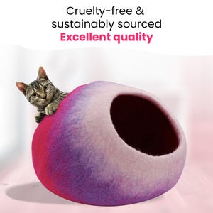 May include: A cat peeks out of a felted cat cave. The cave is a gradient of pink, purple, and white. The text at the top reads "Cruelty-free & sustainably sourced Excellent quality."