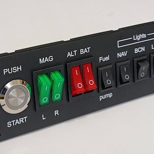 May include: A black rectangular aircraft switch panel featuring a silver push-button starter, two green ignition switches labeled MAG L and R, two red ALT and BAT switches, and a series of black rocker switches for Fuel pump, Lights, and Avionics.