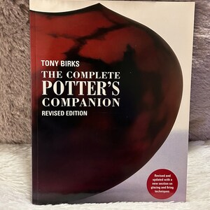 May include: The Complete Potter's Companion, a book with a red and black cover featuring a stylized image of a ceramic pot. The book is a revised edition and includes a new section on glazing and firing techniques.