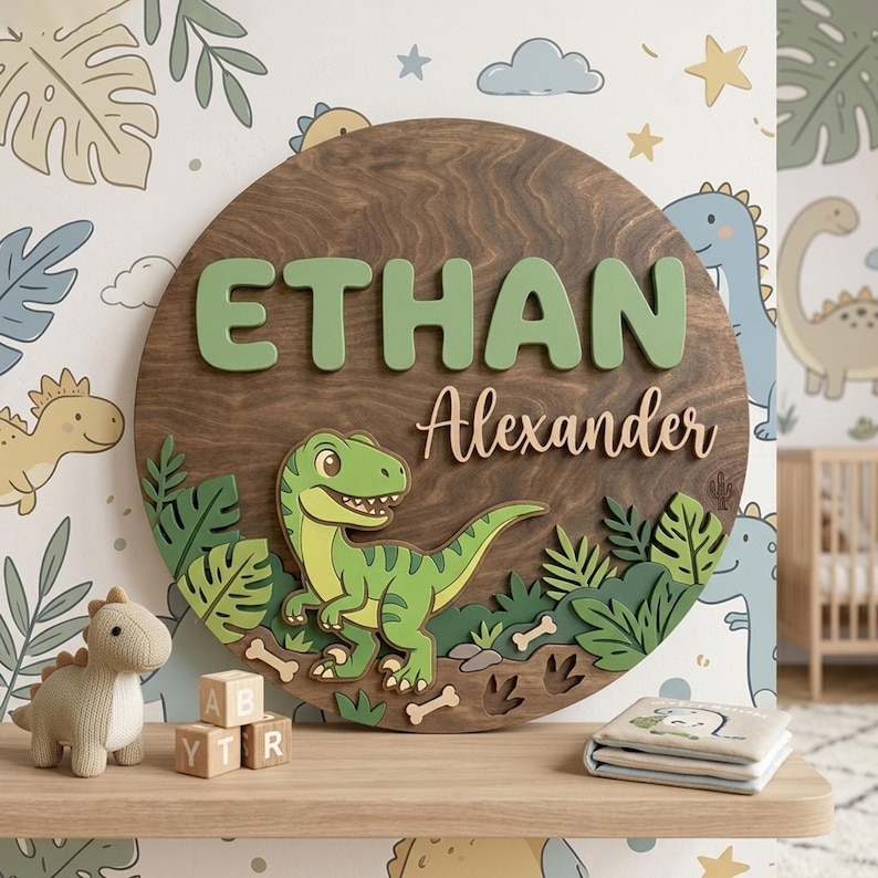 May include: A wooden sign with the name "ETHAN" in green letters and "Alexander" in a cursive font. A green dinosaur is featured on the sign, surrounded by green foliage. The sign is round and has a dark wood grain finish.