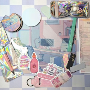 May include: A collection of stationery and accessories, including a pen, stickers, a notepad, and a keychain. The items are arranged on a checkered surface with a pastel color scheme. The notepad has the word "Notes" printed on it.
