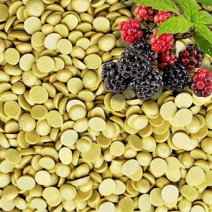 Pode incluir: Vista superior de uma pilha de bolachas de chocolate redondas verde-claro. Amoras e framboesas frescas com folhas verdes são espalhadas por cima. As bagas são de cor vermelho escuro e preto.
