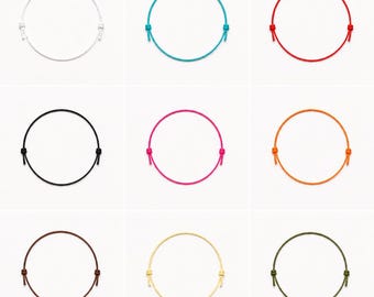 May include: A collection of nine circular cord bracelets arranged in a grid. Each bracelet features a thin, solid-coloured cord with two adjustable sliding knots on opposite sides. The colours include white, turquoise, red, black, pink, orange, brown, yellow, and olive green.