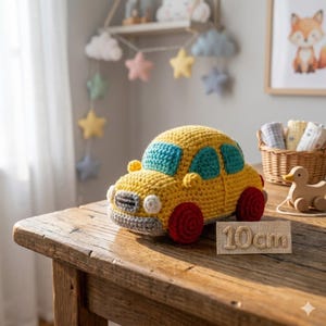 May include: A handmade yellow crochet car toy with blue windows and red wheels. The toy is approximately 4 inches long and sits on a wooden table. A wooden sign next to the car reads "10cm".