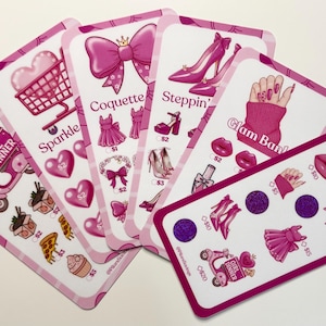 May include: A collection of pink and white cards with illustrations of fashion items, hearts, and text. The cards feature images of a shopping cart, high heels, a bow, and a scooter. The text includes "Girl Dinner", "Sparkle", and "Glam Ban".