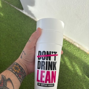 May include: A white insulated tumbler featuring the black text DON'T DRINK LEAN, with the word DON'T crossed out by a horizontal hot pink line. The word LEAN is printed in hot pink, and the text MY SIPPING WORLD appears in a small black box below.