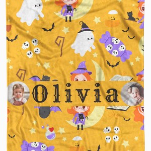 May include: A personalized Halloween-themed blanket in yellow with a repeating pattern of ghosts, witches, bats, and candy. The name "Olivia" is prominently displayed. Includes two small photos.