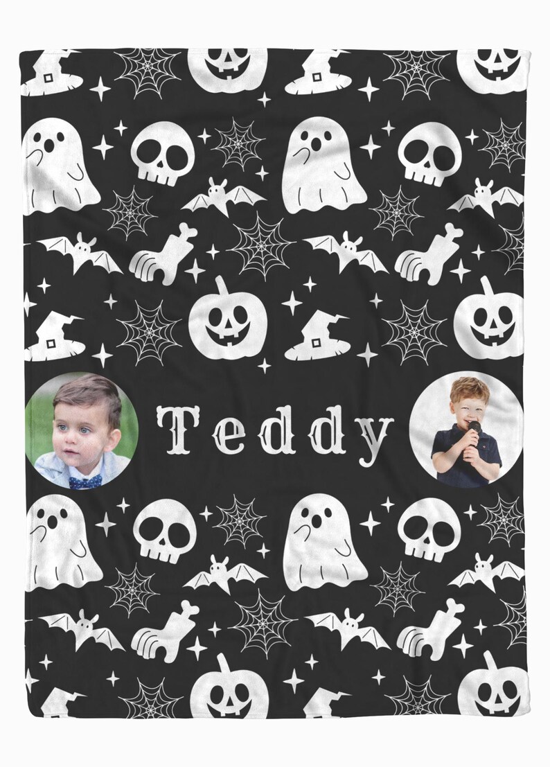May include: Black Halloween-themed blanket with a repeating pattern of white ghosts, skulls, bats, spiderwebs, witch hats, and pumpkins. The name "Teddy" is centered in white text, with two circular photos of a child on either side.