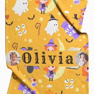May include: Mustard yellow Halloween-themed blanket with cartoon witches, ghosts, bats, and skulls. The name "Olivia" is printed in large black letters. Includes two circular photo inserts.
