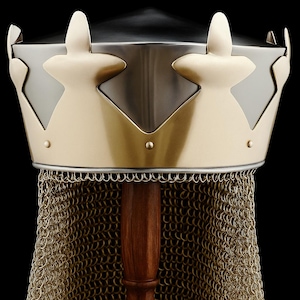 May include: A medieval helmet with a gold crown design and a silver top. It has a chainmail neck guard and is displayed on a wooden stand. The background is black. The helmet's design is reminiscent of historical armour.