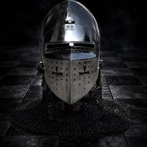 May include: A medieval knight's helmet, crafted from polished metal, features a visor with cross-shaped cutouts and a chainmail neck guard. The helmet's reflective surface and dark background create a dramatic, historical aesthetic.