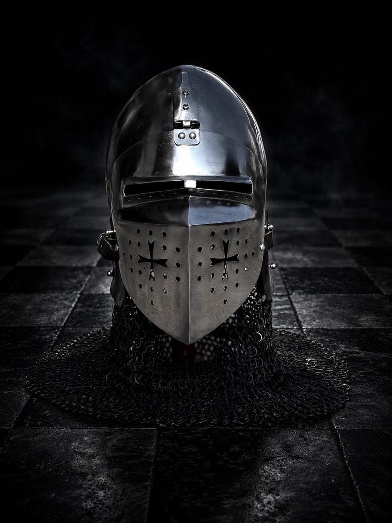 May include: A medieval knight's helmet, crafted from polished metal, features a visor with cross-shaped cutouts and a chainmail neck guard. The helmet's reflective surface and dark background create a dramatic, historical aesthetic.